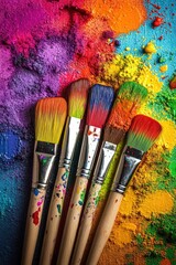 Fototapeta premium Five paintbrushes rest on a vibrant, textured canvas of multicolored powder pigments, showcasing a spectrum of hues and artistic expression