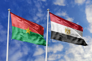 A Burkina Faso and Egypt flag, a metaphor for African unity, wave together against a blue sky, symbolizing friendship and cultural heritage.