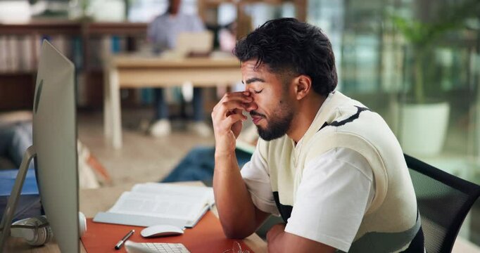 University, tired and man on computer in library for assignment research, project and studying. College, school and person with fatigue, burnout and exhausted for learning, education and online exam
