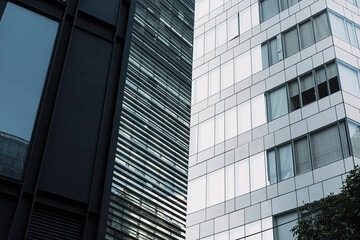 Low angle view of mirrored skyscrapers with light contrast, strong lines and symmetry, background for finance, planning and city business strategy