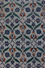 Traditional ceramic tiles featuring an intricate floral pattern in blue, red, and green, showcasing classic Islamic or Ottoman design motifs.