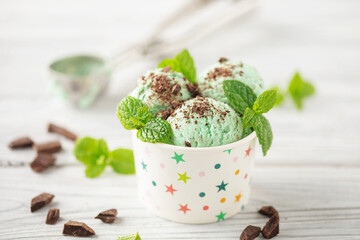 Mint chocolate ice cream balls  in paper bowl on white background