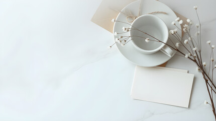 Elegant minimal composition with a white teacup, saucer, and card on a marble surface.
