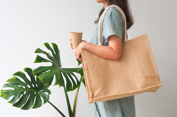 Woman holding  jute bag or sack bag on white background. Reusable shopping bag. Natural material. Zero waste. Plastic free. Eco friendly concept.