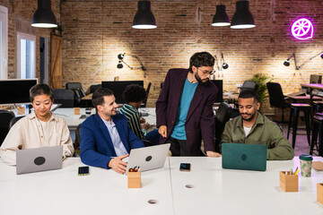 Multi ethnic team collaborating on project in modern office