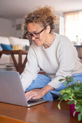 Middle-aged woman working from home on laptop. Mature female freelancer showing different facial...