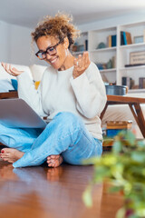 Middle-aged woman working from home on laptop. Mature female freelancer showing different facial...