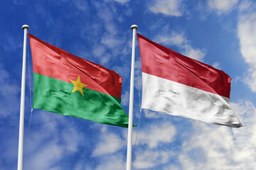 A Burkina Faso and Indonesia flag, a metaphor for Asia-African unity, wave together against a blue...