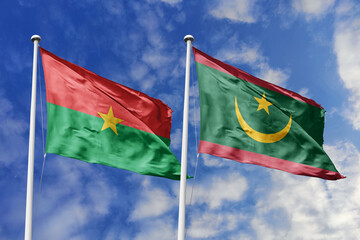 A Burkina Faso and Mauritania flag, a metaphor for West African unity, wave together against a blue...