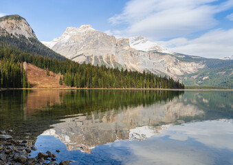 Scenic view of Emerald Lake in Yoho National Park with pine trees and snow-capped mountain with reflected in calm water in Alberta, Canada