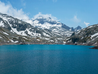 Obraz premium Turquoise Lake and Snowy Peaks in Belledonne Massif – Lac des 7 Laux, French Alps