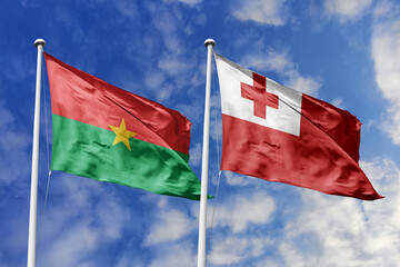 A Burkina Faso and Tonga flag, a metaphor for global unity, wave together against a blue sky, symbolizing friendship and cultural diversity.