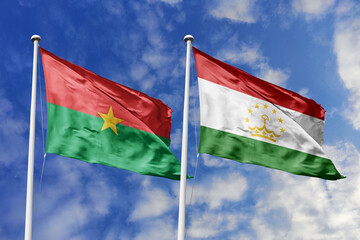 A Burkina Faso and Tajikistan flag, a metaphor for global harmony, wave together against a blue sky, symbolizing friendship and cultural diversity.