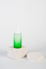 Green glass cosmetic bottle, Skin care or sunscreen cosmetic with stylish props on white background.