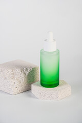 Green glass cosmetic bottle, Skin care or sunscreen cosmetic with stylish props on white background.