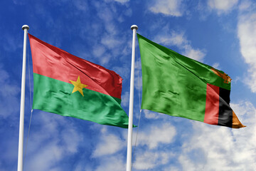 A Burkina Faso and Zambia flag, a metaphor for African solidarity, wave together against a blue sky, symbolizing unity and shared heritage.
