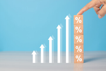 Interest rates and dividends, hand picking wooden blocks with percentage symbol and up arrow, returns on stocks and mutual funds, long term investments for retirement