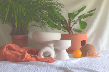 Minimalist decor featuring ceramic planters, textured blanket, and fresh orange, creating serene and inviting atmosphere in garden setting