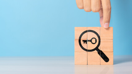 Finding solutions concept. Business problem solving and make decision. New ideas and innovation. Team brainstorming to set strategies. Hand holds wooden cubes with magnifying glass and key icon