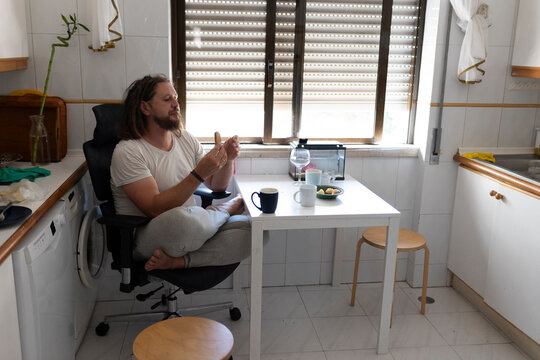 Man eating breakfast in messy kitchen at home