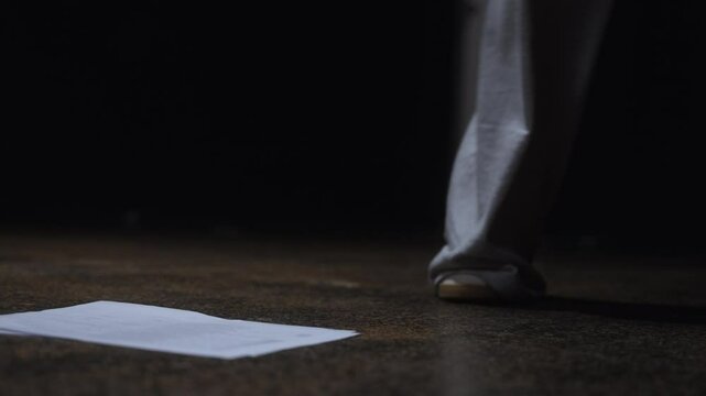 Beautiful slow motion close-up shot of the feet of a couple of actors arriving in a theater practice room to practice a scripted scene.
