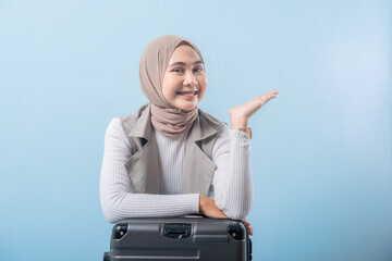 A woman wearing a scarf and pointing to something. She is smiling and she is happy