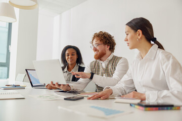 A diverse and dynamic team is actively engaging in a collaborative work session utilizing their...