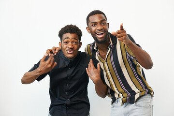Two black men sharing a joyful moment, displaying smiles and playful gestures in a bright setting....