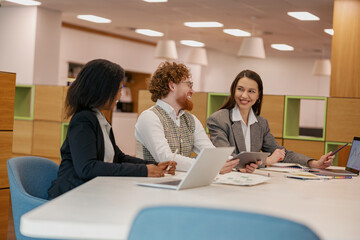 A group of professionals engaged in an intense discussion around a table within a modern and...