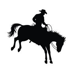 Silhouette of cowboy riding bucking bronco