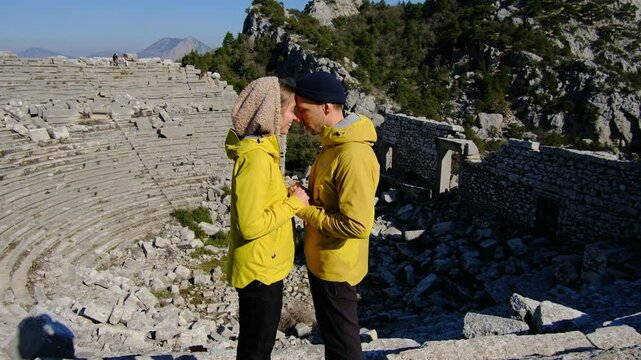 Young travelers discover ancient amphitheater and ruins of Termessos. Walking, climbing, enjoying view and ancient history in warm Turkish light.