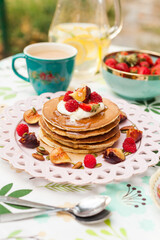 Fluffy pancakes with berries, whipped cream, and nuts. Served with warm milk tea for a sweet and cozy start to the day