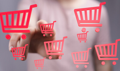 Person interacts with virtual shopping carts, representing online retail and e-commerce.