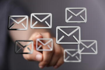 Hand interacts with digital email icons, showing email management or online communication.