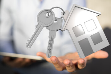 Image of house keys and a small house model in a hand. Perfect for real estate, home buying, or property concepts.