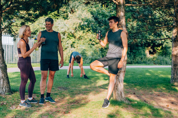 Athletes rehydrating and relaxing in park after workout