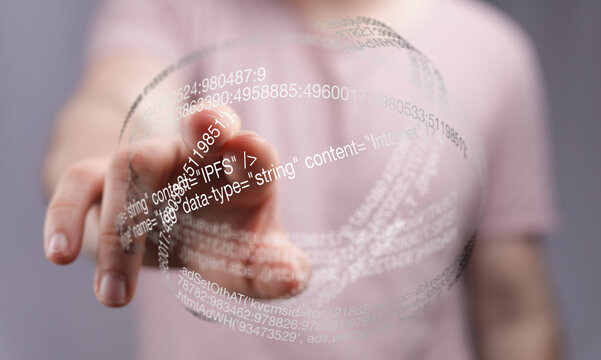 Close-up of a person's hand interacting with a transparent sphere displaying data and code.