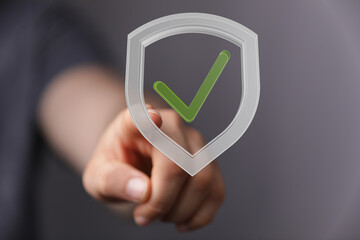 High-quality image of a hand interacting with a digital shield graphic, representing data security and protection.