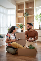 Young couple unpacking belongings in new apartment after moving home