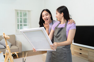 LGBTQIA Couple Sharing Artistic Moments. Two women excitedly presenting their artwork in a bright studio.