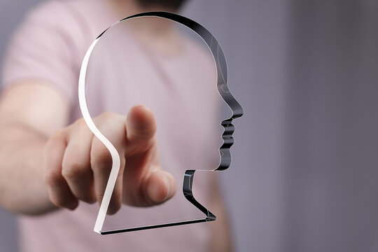 Hand points at a transparent head profile, symbolizing digital identity, AI, or personal data. - Powered by Adobe