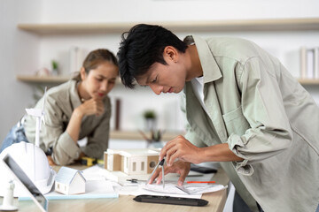 Obraz premium Focused Architects Creating Sustainable Building Plans