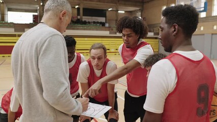 Basketball coach explaining strategy to team - Powered by Adobe
