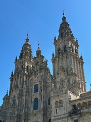 A large stone building with Santiago de Compostela Cathedral in the background