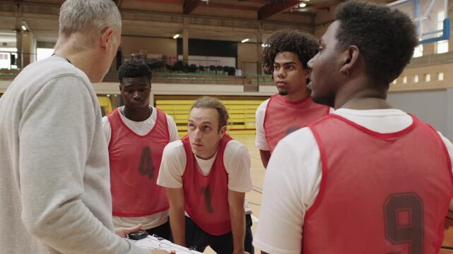 Basketball coach explaining strategy to players