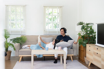Couple enjoying cozy time at home, relaxing on sofa with technology