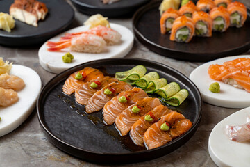 A beautifully arranged platter of sushi delights features salmon, shrimp, and unique rolls served with wasabi and pickled ginger. This vibrant culinary experience invites enjoyment and sharing