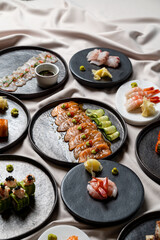 A stunning culinary display of various sushi types is presented on elegant black plates