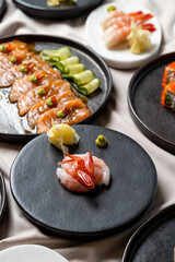 Artfully arranged sushi showcases a variety of fresh seafood, including salmon, shrimp, and delicate cucumber rolls. This elegant display invites a culinary adventure at a modern restaurant