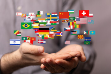 Image of hands holding various flags, symbolizing global connection and international collaboration.